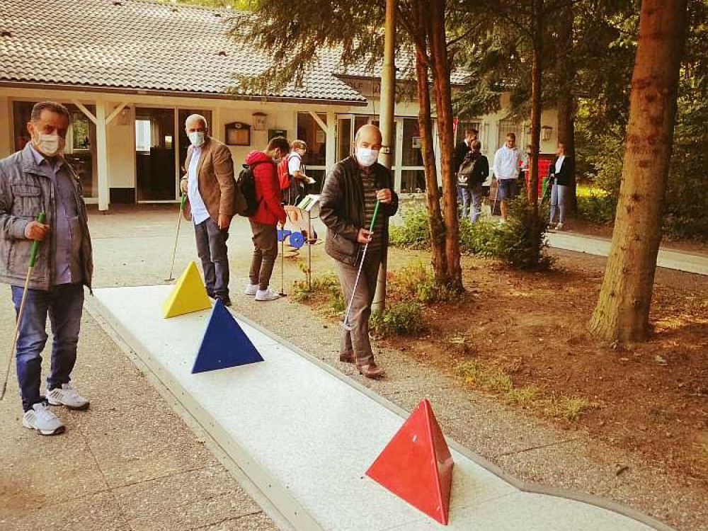 Teilnehmer spielen Corona gerecht Minigolf